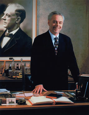 Portrait of John W. Sleeman in front of photograph of his great grandfather George Sleeman Sr. XR1 MS A801 (Box 20, File 10)