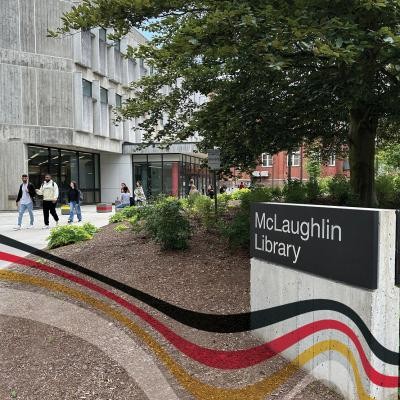 Exterior picture of the McLaughlin Library's entrance from the side with a concreate block name plate that reads McLaughlin Library on the right side of the picture.